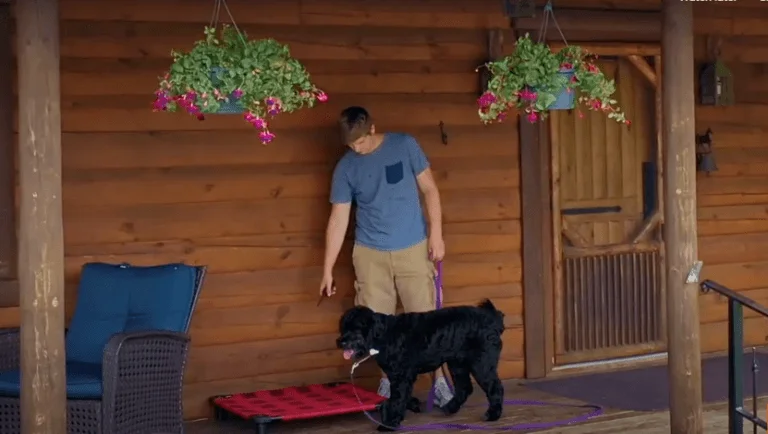 human male with black dog on front porch