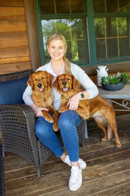 woman with two golden retrievers