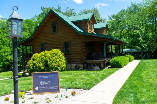 large log cabin with canine academy sign